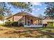 Exterior view of the house featuring a screened lanai, backyard with fresh green grass and landscaping at 4275 Caskie Pl, Brooksville, FL 34604