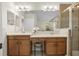 Well-lit bathroom features a double vanity, a makeup counter, and a glass-enclosed tiled shower at 4275 Caskie Pl, Brooksville, FL 34604