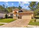 Charming single-Gathering home with a well-manicured lawn, paver driveway, two-car garage, and an inviting arched entryway at 4275 Caskie Pl, Brooksville, FL 34604