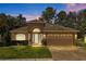 Exterior view of home, showcasing its front facade, arched entrance, and well-kept landscaping at 4275 Caskie Pl, Brooksville, FL 34604