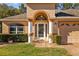 Close up of front entry featuring an arched doorway with decorative columns, glass front door, and neat landscaping at 4275 Caskie Pl, Brooksville, FL 34604