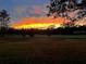 Scenic view of the golf course, showcasing the lush green landscape and vibrant sunset at 4275 Caskie Pl, Brooksville, FL 34604