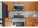 Close-up of a stainless steel oven and microwave in a kitchen with light wood cabinetry at 4275 Caskie Pl, Brooksville, FL 34604