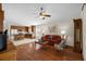 Cozy living room features wood floors, ceiling fan, and a comfortable red sofa, flowing into an open kitchen at 4275 Caskie Pl, Brooksville, FL 34604