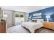 Bright main bedroom with a comfy bed and blue accent wall at 4480 Sand Dollar Way, Zephyrhills, FL 33541