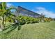 Landscaped backyard with mature trees, leading up to the pool and screened enclosure at 9152 Warm Springs Cir, Parrish, FL 34219