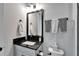 Bathroom features a modern vanity with black countertop, framed mirror and decorative towels at 9152 Warm Springs Cir, Parrish, FL 34219