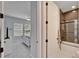 Hallway view into bedroom with bed, leading to view of bathroom with shower-tub combo and herringbone tile at 9152 Warm Springs Cir, Parrish, FL 34219