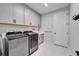 Bright laundry room featuring cabinets, sink, and modern washer and dryer at 9152 Warm Springs Cir, Parrish, FL 34219
