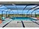 Sparkling screened in pool with spa, waterfalls, and pavers, overlooking a serene lake at 9152 Warm Springs Cir, Parrish, FL 34219