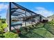 Landscaped backyard featuring a screened in swimming pool and view of a well manicured lawn at 9152 Warm Springs Cir, Parrish, FL 34219