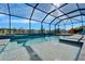 Sun-drenched pool area features a spa and sun shelf, all within a screened enclosure with lush landscaping views at 9152 Warm Springs Cir, Parrish, FL 34219