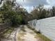 A long driveway flanked by a mix of wooden and metal fencing leads to a secluded property at 1319 Vance Rd, Plant City, FL 33566