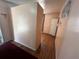 Hallway featuring neutral paint and wood-look flooring to another room with a door at 1319 Vance Rd, Plant City, FL 33566