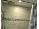 Tiled shower with a shower head, body sprayer and pebble stone detail at 1330 70Th N St, St Petersburg, FL 33710