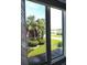 Relaxing view through a window with palm trees, greenery, and streetscape beyond at 1330 70Th N St, St Petersburg, FL 33710