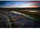 An aerial view of a community showcases the serene landscape, lake, neighborhood streets, and tree line at 32317 Rosewood Meadow Ln, Wesley Chapel, FL 33543