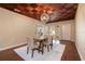 Dining room featuring a striking decorative ceiling, wood floors, and a modern light fixture at 1608 Pinellas Rd, Belleair, FL 33756