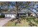 Inviting single-story home with brick driveway, two-car garage, and mature shade trees at 1608 Pinellas Rd, Belleair, FL 33756