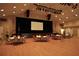 A large auditorium with a stage, projection screen, and rows of tables and chairs, ideal for events at 11021 Edge Park Dr, Hudson, FL 34667