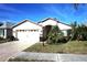 Charming single-story home featuring a two-car garage, manicured lawn, and lush tropical landscaping at 11021 Edge Park Dr, Hudson, FL 34667