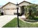 Charming single-story home featuring a two-car garage, manicured lawn, and tropical landscaping at 11021 Edge Park Dr, Hudson, FL 34667