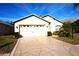 Well-maintained one-story home with a two-car garage, beautiful landscaping, and a patterned driveway at 11021 Edge Park Dr, Hudson, FL 34667