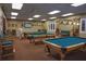 A well-lit game room features multiple billiard tables and ample seating around the room at 11021 Edge Park Dr, Hudson, FL 34667