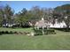 Charming community gazebo nestled on a grassy lawn with mature trees providing shade at 11021 Edge Park Dr, Hudson, FL 34667