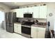 Modern kitchen with stainless steel appliances, white cabinets, granite countertops, and tiled backsplash at 11021 Edge Park Dr, Hudson, FL 34667