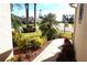Sidewalk view of attractive landscaping featuring mature palm trees and colorful flowering plants at 11021 Edge Park Dr, Hudson, FL 34667