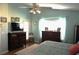 Bright main bedroom with large window, wood floors, ceiling fan, and a wooden dresser at 11021 Edge Park Dr, Hudson, FL 34667