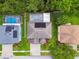 Aerial view of the property features a large private pool, lush landscaping, and solar panels at 15815 Muirfield Dr, Odessa, FL 33556