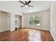 Bedroom featuring hardwood floors, neutral-toned walls, a ceiling fan, a window, and walk-in closets at 15815 Muirfield Dr, Odessa, FL 33556