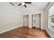 Bedroom featuring hardwood floors, neutral-toned walls, a ceiling fan, a window, and walk-in closets at 15815 Muirfield Dr, Odessa, FL 33556