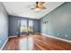 Bedroom featuring hardwood floors, a ceiling fan and two large windows with natural lighting at 15815 Muirfield Dr, Odessa, FL 33556