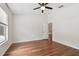 Bedroom featuring hardwood floors, neutral-toned walls, a ceiling fan, a window, and an open door at 15815 Muirfield Dr, Odessa, FL 33556
