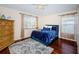 Comfortable bedroom featuring hardwood floors and a stylish blue bed at 15815 Muirfield Dr, Odessa, FL 33556