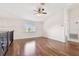 Bright bonus room featuring rich wood floors, a modern ceiling fan, and a window offering views at 15815 Muirfield Dr, Odessa, FL 33556