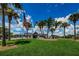 Charming clubhouse framed by palm trees and a vibrant green lawn, under a clear blue sky at 15815 Muirfield Dr, Odessa, FL 33556