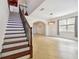 Bright entryway featuring tile flooring, a staircase with wood and iron railings, and arched doorway at 15815 Muirfield Dr, Odessa, FL 33556