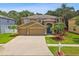 Inviting home featuring a spacious driveway, three-car garage, landscaped yard, and a blue front door at 15815 Muirfield Dr, Odessa, FL 33556