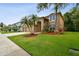Beautiful two-story home with a large, green lawn, palm trees, and a well-maintained landscape at 15815 Muirfield Dr, Odessa, FL 33556