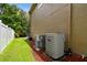 Exterior view of a home with air conditioning units and a well-maintained lawn at 15815 Muirfield Dr, Odessa, FL 33556