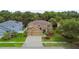 Two-story home featuring a three-car garage, well-maintained lawn, and mature landscaping at 15815 Muirfield Dr, Odessa, FL 33556