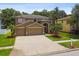 Beautiful two-story home with a spacious driveway, three-car garage, and lush, green lawn at 15815 Muirfield Dr, Odessa, FL 33556
