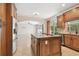 Beautiful kitchen with wooden cabinets, granite island and stainless appliances open to the living area at 15815 Muirfield Dr, Odessa, FL 33556