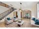 Bright living room featuring a staircase, seating, and an open layout leading to a dining area at 15815 Muirfield Dr, Odessa, FL 33556
