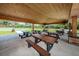 Community picnic area with covered pavilion, tables, benches, and ceiling fans, great for outdoor gatherings at 15815 Muirfield Dr, Odessa, FL 33556