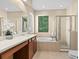 Bright bathroom featuring a double vanity, separate tub, and glass-enclosed shower for a luxurious feel at 20314 Chestnut Grove Dr, Tampa, FL 33647